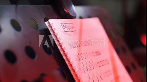 Music sheets notebook on perforated stand in studio closeup. Musical score on exercise book page for artist in audio recording premise