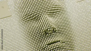 The animation showcases an array of pins coming together to form a 3D face, demonstrating the concept of pin art. This creative representation highlights the versatility and depth that can be achieved