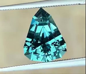 $600 USD . 3.24 ct. Namibian Indicolite Tourmaline in a custom shield . Dimensions:11.12x8.60x6.21mm . This is a fantastic gem Indicolite tourmaline cut in a nice custom shield. In natural light this stone exhibits a nice blue color. Inside under incandescent light it takes on a remarkable crisp teal color. This material is not to be confused with the darker closed afghani tourmaline. The rough was procured from Beau Patterson from a larger Tourmaline parcel he got nearly 15 years ago. I was for