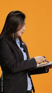 Vertical Video Stylish person ordering clothes online on modern pc, using debit card to make electronic transaction in studio. Young woman typing banking credentials on website for shopping session.