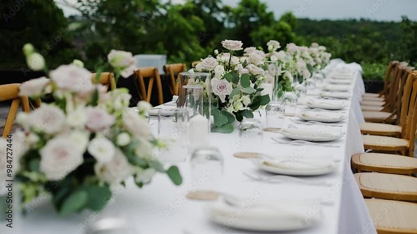 Luxury romantic dinner setup and design for marriage and catering wedding table setting with flowers, candles, old fashioned chairs at small cozy wedding party, slow motion.