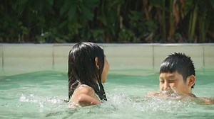 Boy and girl having fun at swimming pool, healthy concept