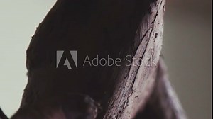 Artist modeling a clay human figure. Craftsman artist making craft, pottery. Process of making a clay figure. Clay figure is an antique man. Close-up: a sculptor's stack. Tool for processing clay