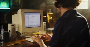 Back View Of Caucasian Male Software Engineer Programming on Old Desktop Computer In Retro Garage. Focused Man Starting Tech Startup Company In Nineties. Coding Innovative Online Service At Home. vídeo do Stock