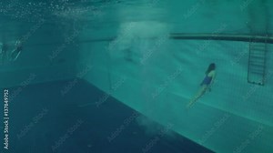 Diving (Jumping into the water), female athlete entry into the water, underwater view.