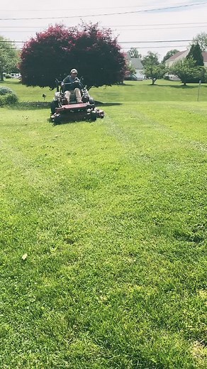 Operating a Red and Black Riding Lawn Mower