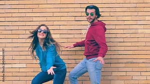 funny couple performs synchronized steps in hip hop style in front of the camera