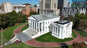 Virginia state capitol building in downtown Richmond, VA. Aerial descending shot towards ornate white government building with pillars.