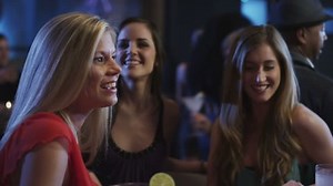Three young women enjoy their night out on the town at a bar