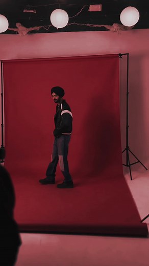 Stylish Male Model Poses Against Red Studio Backdrop