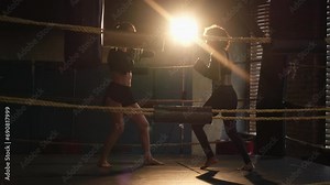 Women self defense power. Woman fighter boxer and personal trainer training in gym teaching mma fitness punching with boxing gloves. Healthy strong girl punching training punches. Fit body workout