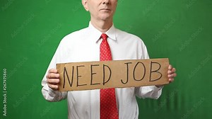 An unemployed senior man in a white shirt and tie holds a sign saying "need job" looking for employment. Shot on a green screen background.