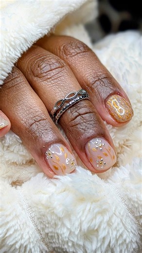 Edith A. on Instagram: "Le tout premier frisson de l’hiver mais version glowy & classy… un vrai Shine for Winter comme on aime ✨❄️ Entre le petit chocolat chaud sous plaid, la neige qui danse derrière la fenêtre et les lumières dorées, les ongles apportent exactement la même vibe : douceur, chaleur et éclat. ✨ Gainage ongles naturels pour une base clean & soignée, 🎨 Nail art sur mesure entièrement à main levée, 🌟 Et surtout… ce mélange de paillettes fines, de doré fondu et de feuilles stylisée