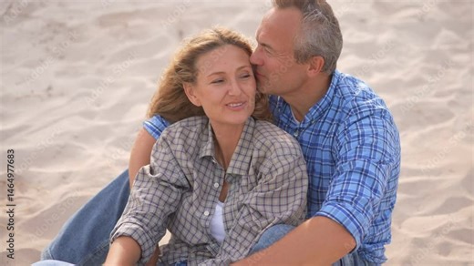 Romantic middle-aged couple enjoying a peaceful evening together on the beach. Love, connection, and togetherness concept for mature relationships and slow living lifestyle.