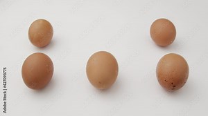 Creative flat lay pattern of Organic eggs on white background. happy easter scene woman hand puts egg on the white table pattern.