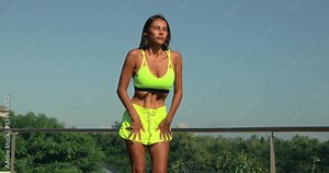 Beautiful latino girl makes a stomach vacuum yoga asana. Nauli kriya training for the abdominal muscles. Young woman conducts online training during a pandemic. Self-isolation training online.