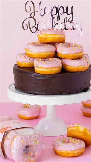 Get ready for the ultimate party on a plate! 🎂🎉 Why choose between cake and donuts when you can have both?! Our Goofy Round Chocolate Cake topped with Strawberry Carnival Sprinkle Donuts is the real icing on the cake (😉)! 🍩🐵 Tag someone who needs this masterpiece for their next birthday! | Original Foods Baking Co.