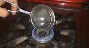 Put the metal sieve near the stove flame: the easy way to clean it