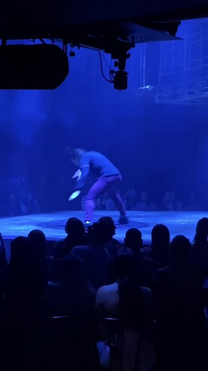 Dynamic Dance Performance Under Blue Stage Lighting