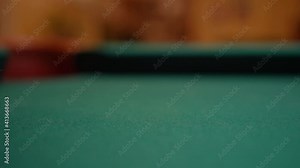 Closeup of Solid Yellow One Ball Being Shot into the Corner Pocket Hard by the White Cue Ball on a Brunswick Pool Table with Green Felt or Cloth, No Faces Playing Billiard Bar Games