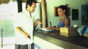 Woman at the reception of a hotel gives information to a lost tourist