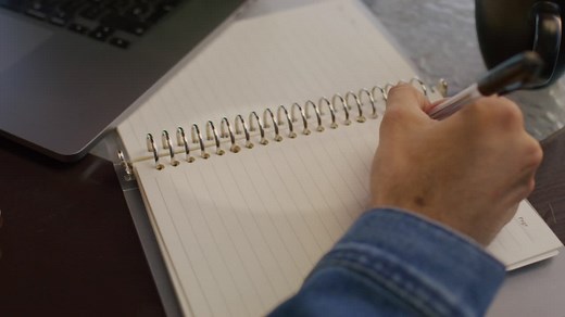 Close up a hand writing notes on a notebook with a pen - Free Stock Video