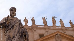 View of a statue at the Saint Peter Square with Saint Peter Basilica on the background in Vatican City