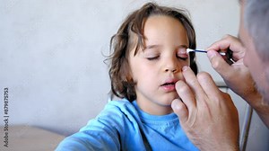 doctor treats an insect bite on a child's face with a cotton bud and allergy ointment, insect bite bruise under the eye, insect bite allergy