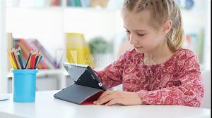 Little girl using digital tablet for learning during school lesson