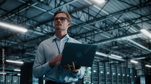 Big Data Center Chief Technology Officer Using Laptop Computer. Server Farm Cloud Computing Facility with System Administrator Working. Software as Solution and Cloud Computing with Cyber Security