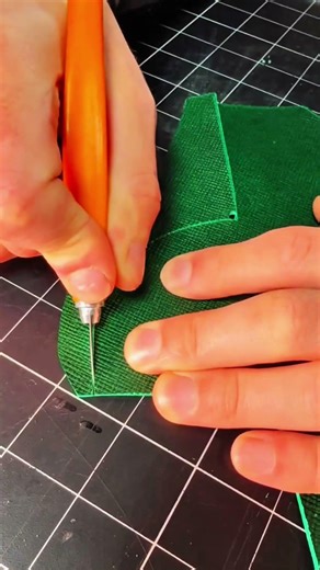 Blue stencil overlaying green fabric on cutting mat