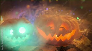 Beautiful carved pumpkins with sparklers inside in thick fog close-up decorating halloween party.