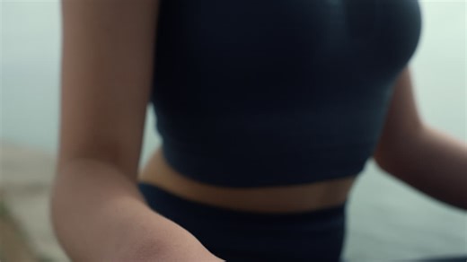 Relaxed woman sitting lotus pose practicing yoga meditation on beach close up. | Premium Stock Video Footage