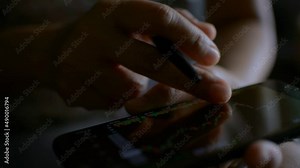 Close up fingers of businesswoman scrolling on mobile phone touchscreen at home. Checking stock market data. Stock market graph simulator on a smartphone screen. Business and finance.