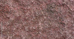 the structure of a red stone with other colors, a close-up of a large stone in the park