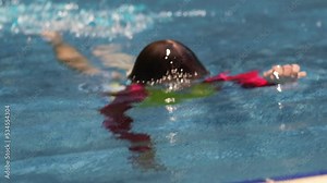 boy swims underwater in the pool top view. a small child emerges from under the water and takes off his goggles for swimming Stock Video