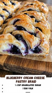 Blueberry Cream Cheese Pastry Braid: A bakery-style treat right in your own kitchen! 🫐🥐 Flaky, buttery puff pastry is braided over a sweet, tangy cream cheese filling dotted with juicy blueberries. Baked until golden and drizzled with vanilla glaze, it's perfect for a special holiday breakfast or a decadent dessert. #BlueberryBraid #PuffPastryRecipe #CreamCheeseDanish #BreakfastPastry #BlueberryDessert #EasyBaking #BrunchRecipes #DanishPastry #HomemadePastry #SweetBreakfast #ComfortFood #Pinte