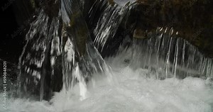 Small waterfall on brook in dark woods