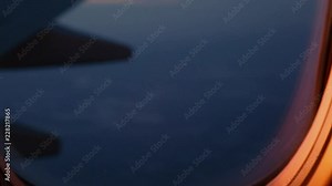 A view out of an aircraft window looking over the wing at sunset.