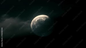 The moon shrouded in a thin veil of clouds partially covered by the Earths shadow during a striking lunar eclipse. . .