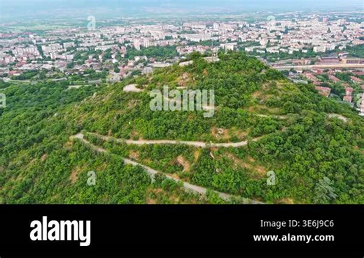 Ancient intermountain town Plovdiv with old residential houses and green fields, against backdrop of Rhodope Mountains and hills covered with spruce forests and overcast sky. UHD 4K video realtime Stock Video Footage - Alamy
