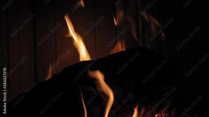 Burning Flame At Fireplace on wooden logs. Medium shot of a yule log burning in a fireplace.