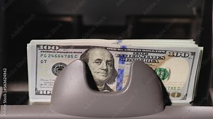 Money Counter Making Stack Of Hundred Dollar Bills. Currency cash counting machines, financial institution. Close up of currency counting machine counting dollar bills.