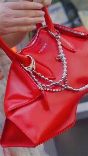 McQueen on Instagram: "The McQueen Manta – @abigaille___ from @thelastdinnerparty, Paris. Vivid red leather with angular folded edges. Finished with the Pearl and Skull double chain charm. McQueen Spring Summer 2026 Pre-collection. Art Director: @SJ_Todd_ Photographer: @Camille_Vivier Styling: @CamilleBWaddington Video: @Chanel.JM Hair: @GaryGillHair Make-up: @Daniel_S_Makeup Nails: @Romane_Martini Music: Joss Davy"