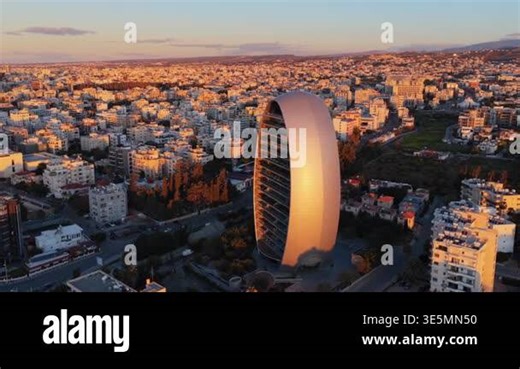 Aerial drone view of Limassol skyline featuring Oval Building with modern architecture and dense urban layout at golden hour Stock Video Footage - Alamy