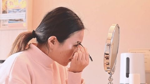 clip-3996258419-woman-applying-eyebrow-makeup-beauty