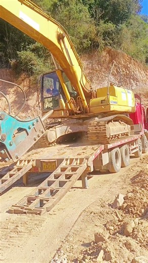 Heavy Machinery Load-Up: Excavator Boarding a Transport Truck