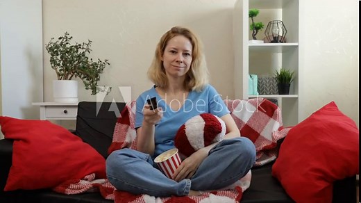 Woman watching tv on sofa at home, person using remote for cinema, leisure time and enjoyment in the room