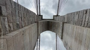 Looking straight up underneath a Brooklyn bridge support with cables that span between Brooklyn and Manhattan across the East River.