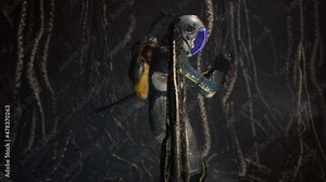 An astronaut with a fantastic weapon slowly walks through the catacombs of an alien planet inhabited by nightmarish animals. Alien cave with tentacles. The animation is perfect for sci-fi backgrounds.